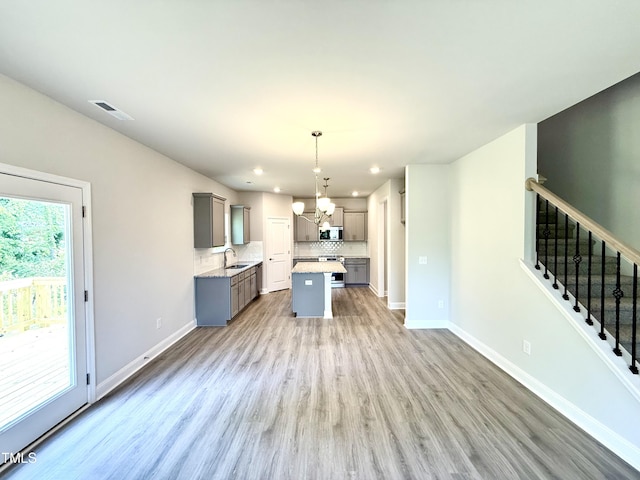 kitchen with visible vents, an inviting chandelier, a sink, gray cabinetry, and stainless steel appliances