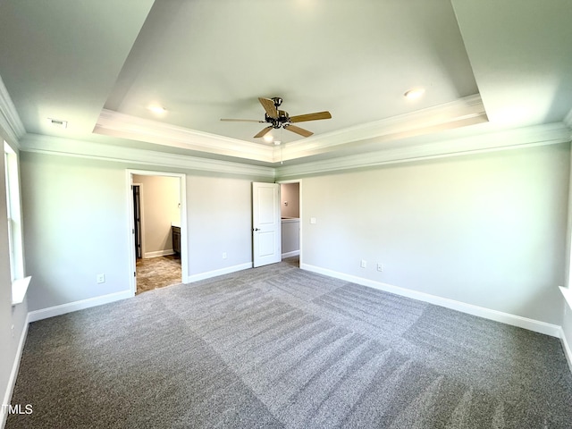 unfurnished bedroom with crown molding, baseboards, carpet flooring, and a raised ceiling