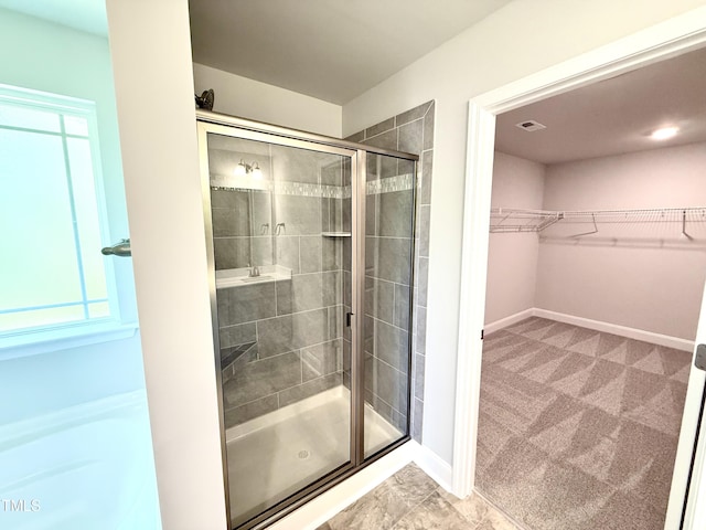 full bathroom with baseboards, a spacious closet, and a shower stall