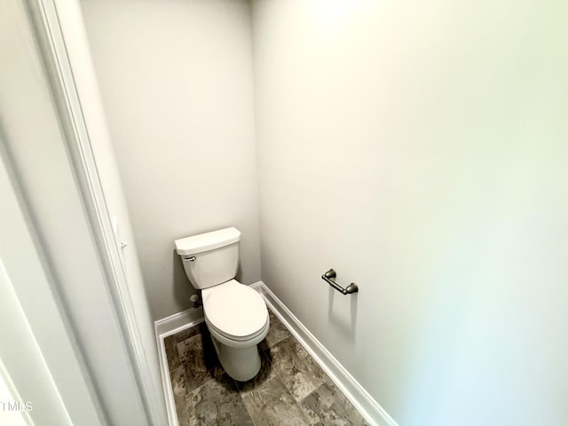 bathroom featuring baseboards and toilet