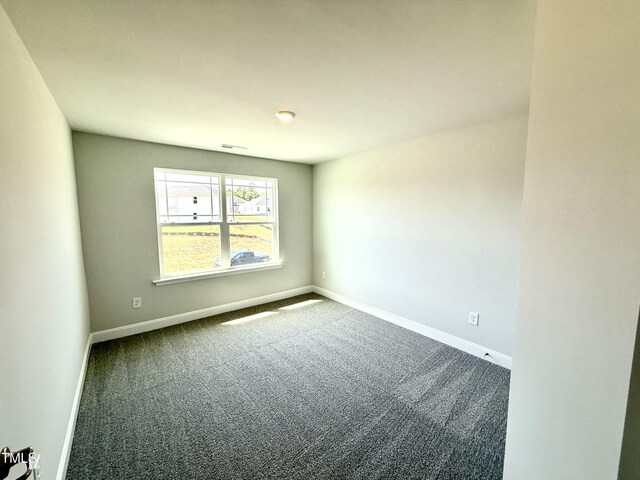 spare room with baseboards, carpet, and visible vents