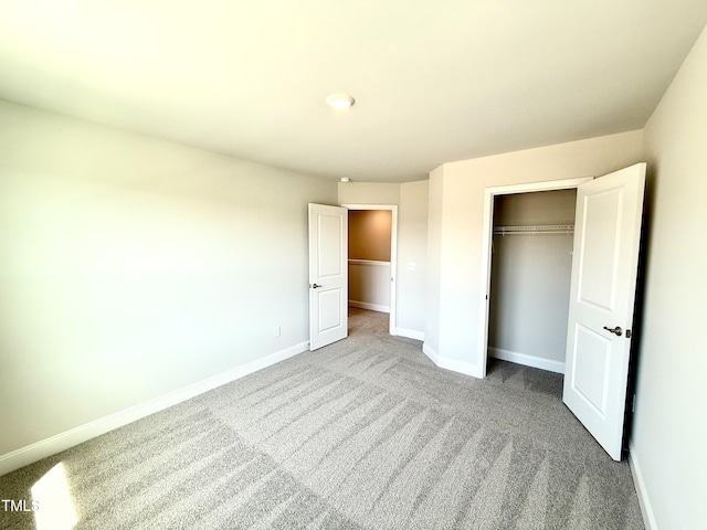 unfurnished bedroom with carpet flooring, baseboards, and a closet