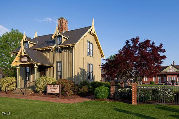 exterior space featuring a lawn, fence, board and batten siding, and a chimney