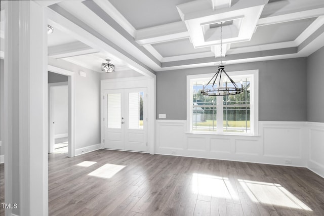 foyer entrance featuring beamed ceiling, a notable chandelier, wood-type flooring, coffered ceiling, and french doors