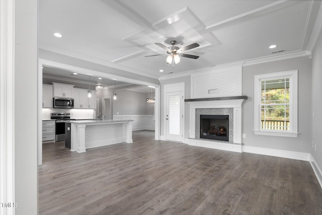 unfurnished living room with hardwood / wood-style floors, ceiling fan, and crown molding