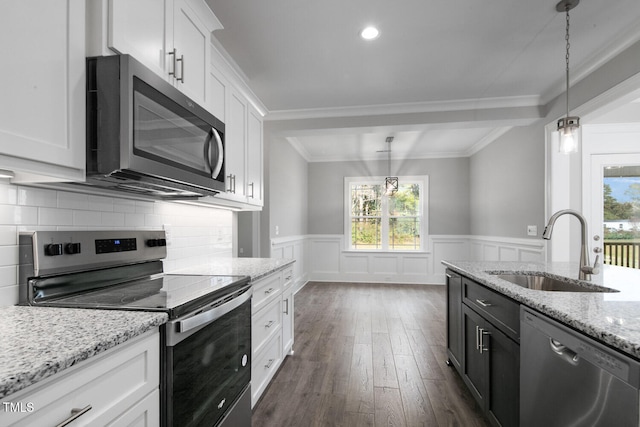 kitchen with white cabinets, sink, decorative light fixtures, and appliances with stainless steel finishes