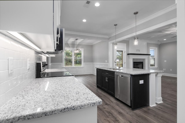 kitchen featuring dark hardwood / wood-style flooring, hanging light fixtures, stainless steel dishwasher, and an island with sink