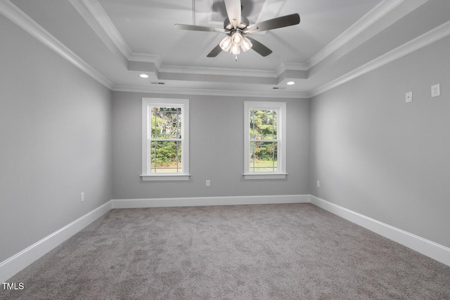 carpeted spare room featuring ceiling fan, a tray ceiling, and ornamental molding