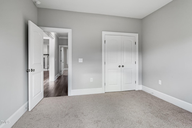 unfurnished bedroom with a closet and dark colored carpet