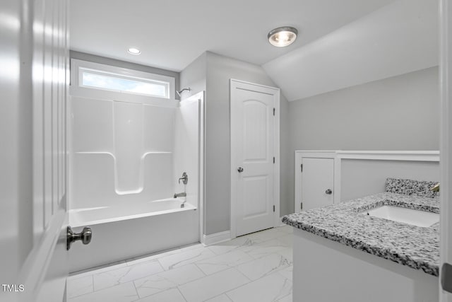 bathroom with vanity, vaulted ceiling, and  shower combination