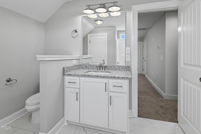 bathroom with vanity, toilet, and vaulted ceiling