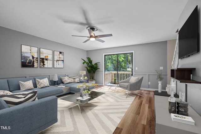 living room featuring wood-type flooring and ceiling fan