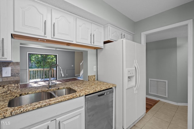 kitchen with dishwasher, sink, stone countertops, a textured ceiling, and white cabinetry