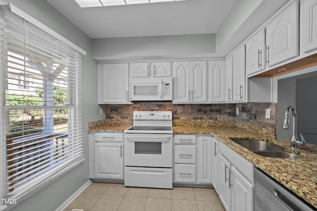 kitchen featuring white appliances, white cabinetry, sink, and decorative backsplash