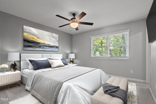 carpeted bedroom with a textured ceiling and ceiling fan