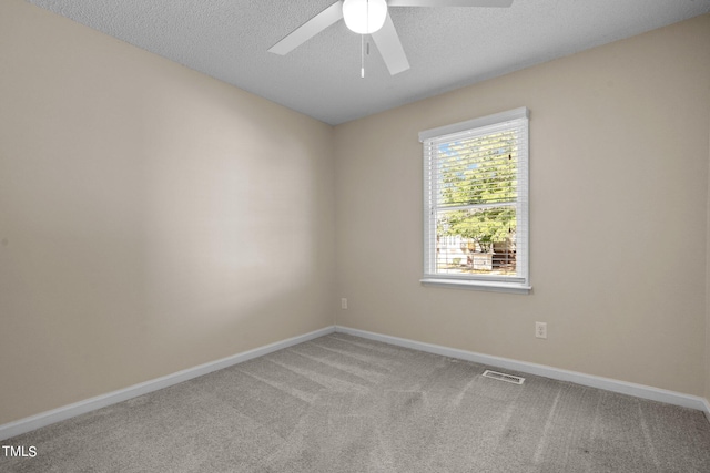 empty room with ceiling fan, a textured ceiling, and light colored carpet