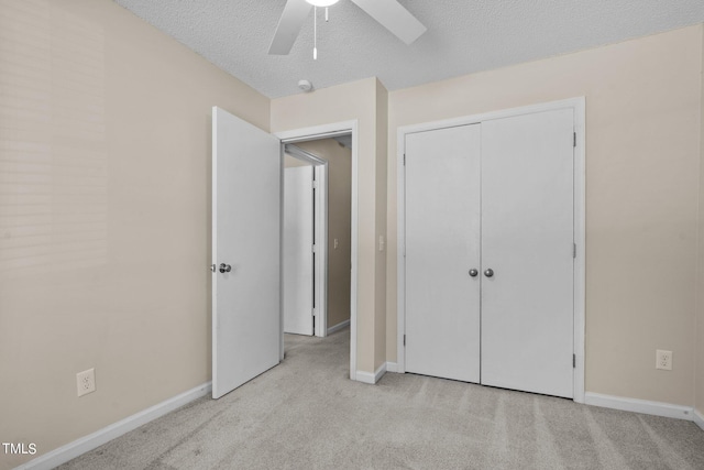 unfurnished bedroom with a closet, ceiling fan, a textured ceiling, and light colored carpet