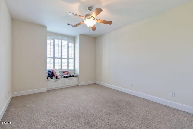 unfurnished room with light colored carpet and ceiling fan