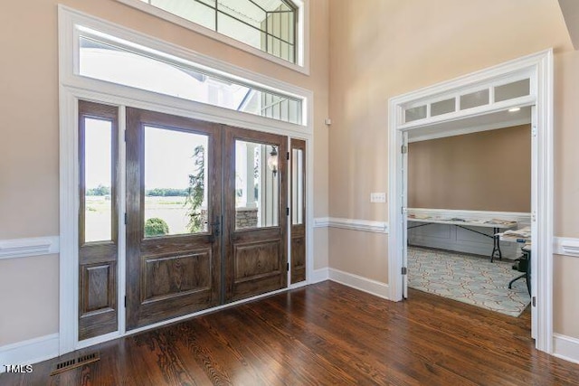 foyer featuring french doors, dark hardwood / wood-style floors, and a high ceiling