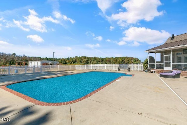 view of pool with a sunroom and a patio area