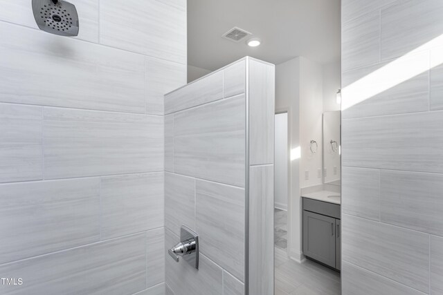 bathroom featuring vanity and a tile shower