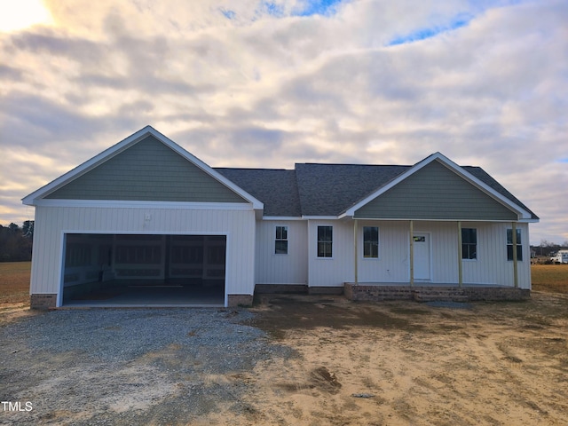 single story home featuring a porch and a garage