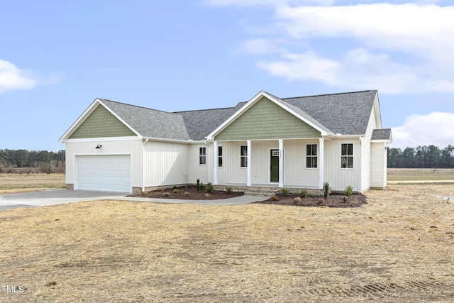 view of front facade featuring a garage, a porch, driveway, and a shingled roof