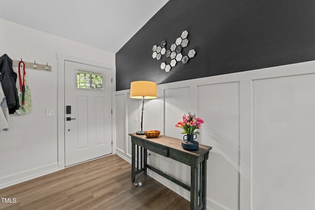 6125 Bellow St, Raleigh, NC 27609 - entrance foyer with wood finished floors, vaulted ceiling, a decorative wall, and wainscoting