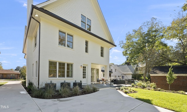 exterior space with cooling unit, a patio area, an outdoor hangout area, and a front yard