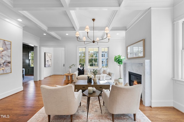 living room featuring beam ceiling, light hardwood / wood-style floors, a high end fireplace, and coffered ceiling