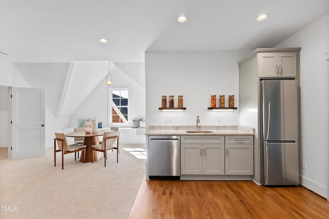 kitchen featuring gray cabinetry, sink, vaulted ceiling, light hardwood / wood-style flooring, and stainless steel appliances