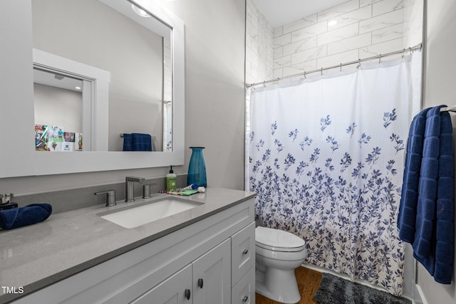 bathroom with vanity, hardwood / wood-style flooring, toilet, and walk in shower