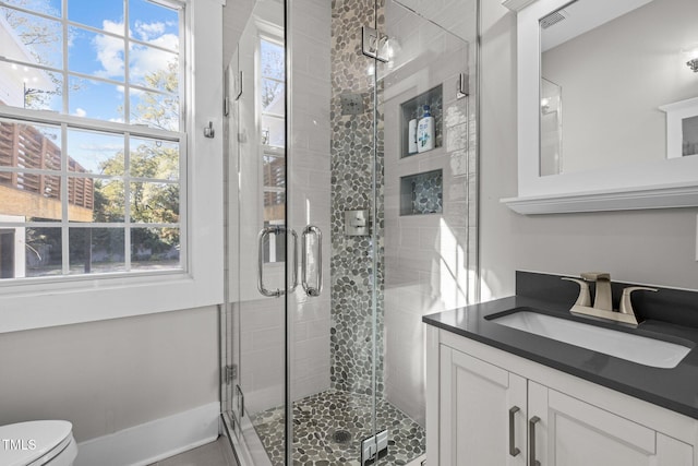 bathroom with vanity, toilet, and an enclosed shower