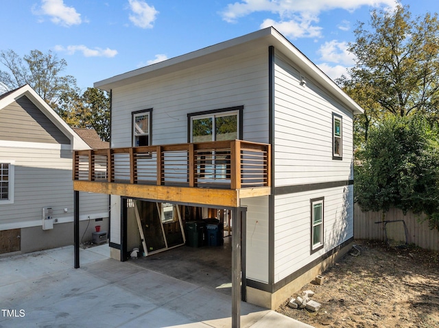 back of property with a deck and a patio