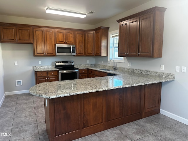 kitchen featuring stainless steel appliances, sink, kitchen peninsula, light stone counters, and light tile patterned floors