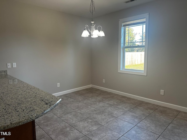 unfurnished dining area featuring an inviting chandelier and light tile patterned flooring