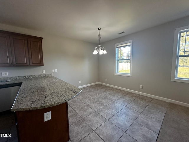 kitchen featuring decorative light fixtures, kitchen peninsula, light tile patterned flooring, light stone countertops, and a chandelier