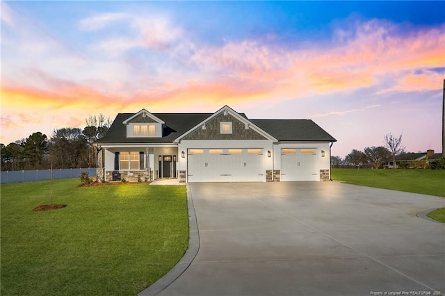 modern farmhouse style home with concrete driveway, a yard, stone siding, and an attached garage