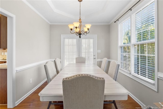 dining area featuring crown molding, an inviting chandelier, and dark hardwood / wood-style flooring