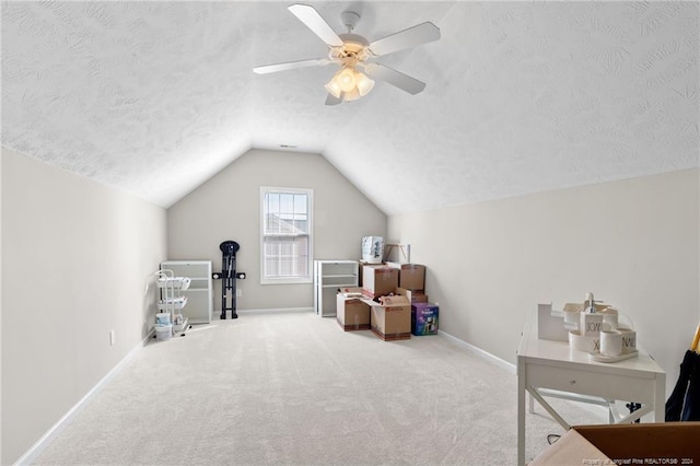 interior space featuring lofted ceiling, carpet floors, a textured ceiling, and ceiling fan