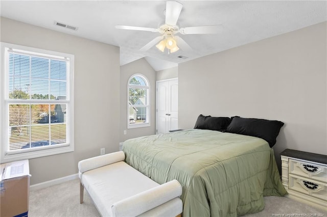 bedroom featuring vaulted ceiling, light carpet, a closet, and ceiling fan