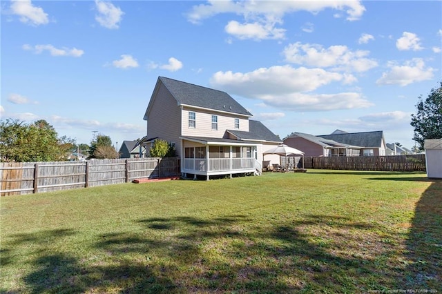 rear view of house with a sunroom and a lawn