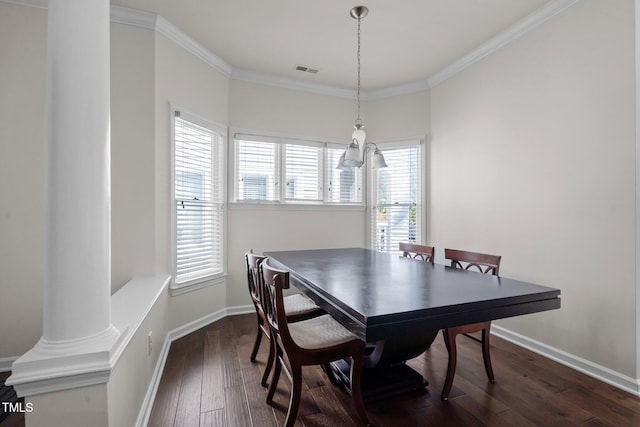 dining space featuring dark wood-type flooring, ornamental molding, and ornate columns