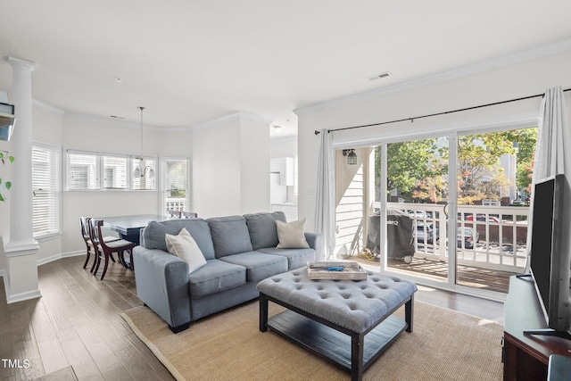 living room with crown molding, hardwood / wood-style flooring, and decorative columns