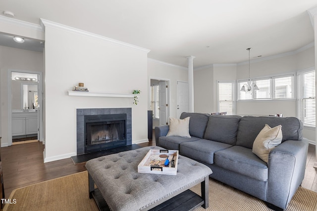 living room featuring dark wood-type flooring, ornamental molding, and a healthy amount of sunlight