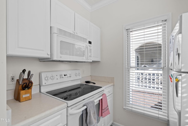 kitchen featuring white cabinetry, crown molding, and white appliances