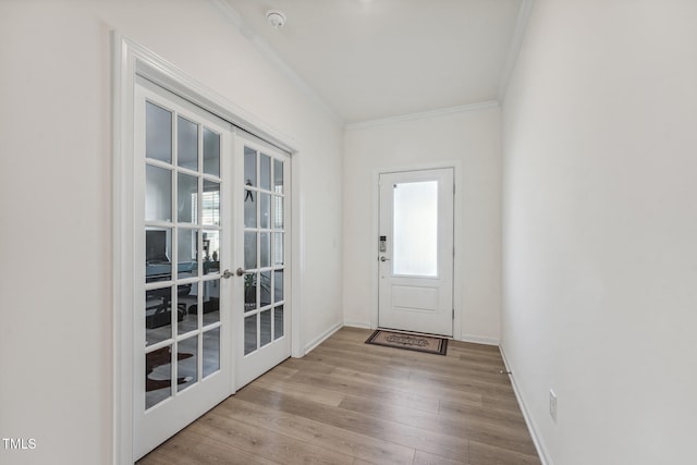 entryway featuring ornamental molding, french doors, and light hardwood / wood-style flooring