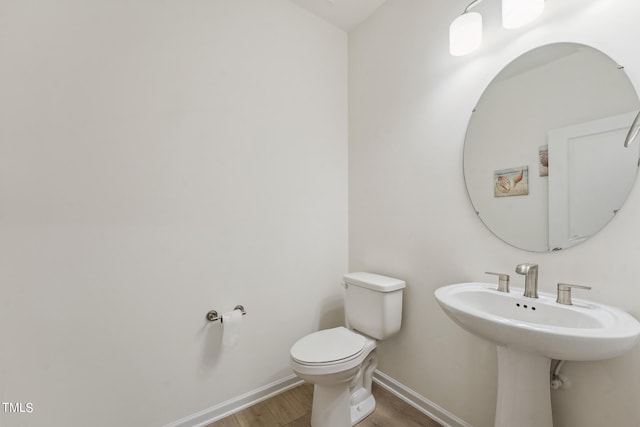 bathroom featuring hardwood / wood-style flooring and toilet