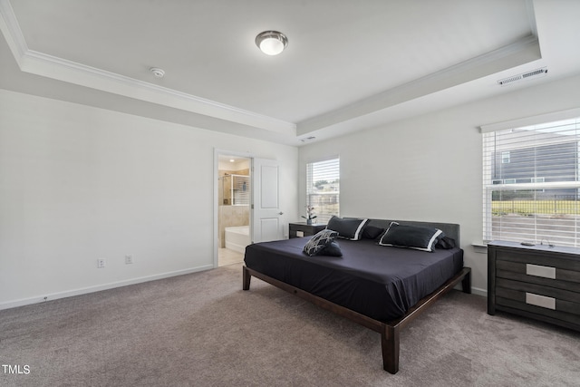 carpeted bedroom with multiple windows, ensuite bathroom, a tray ceiling, and crown molding