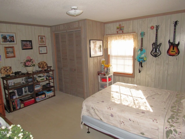 carpeted bedroom featuring a closet, wood walls, and a textured ceiling